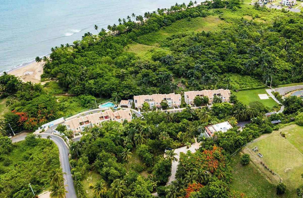 Aerial view of the estate on a green hillside above the bay