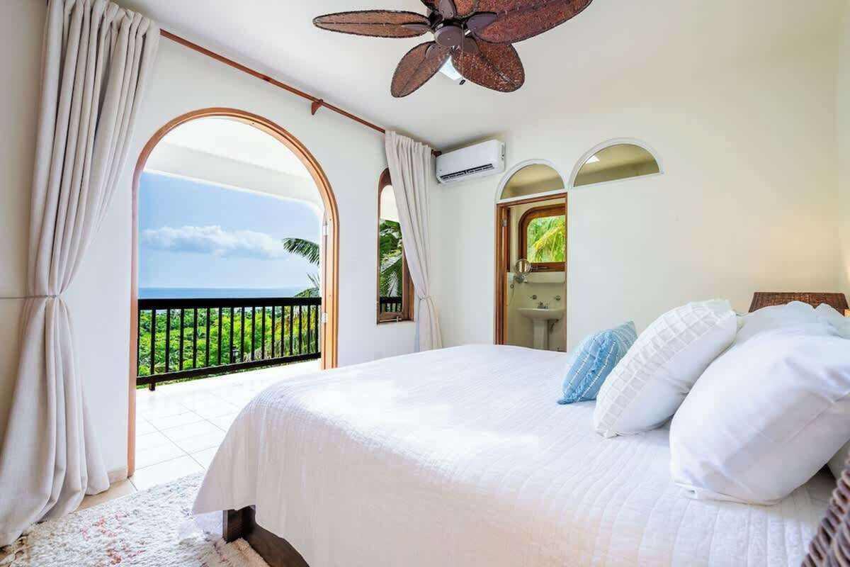 Bright bedroom with ceiling fan and garden windows