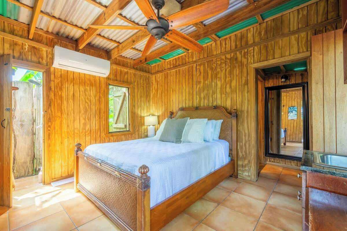 Wood-panelled cabana suite bedroom with air conditioning