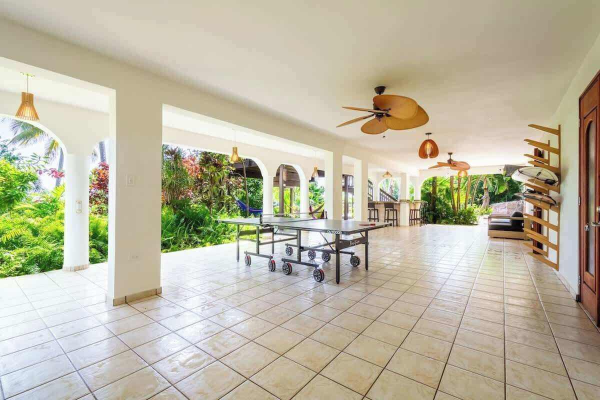 Open-air tiled pavilion with dining table and ceiling fans