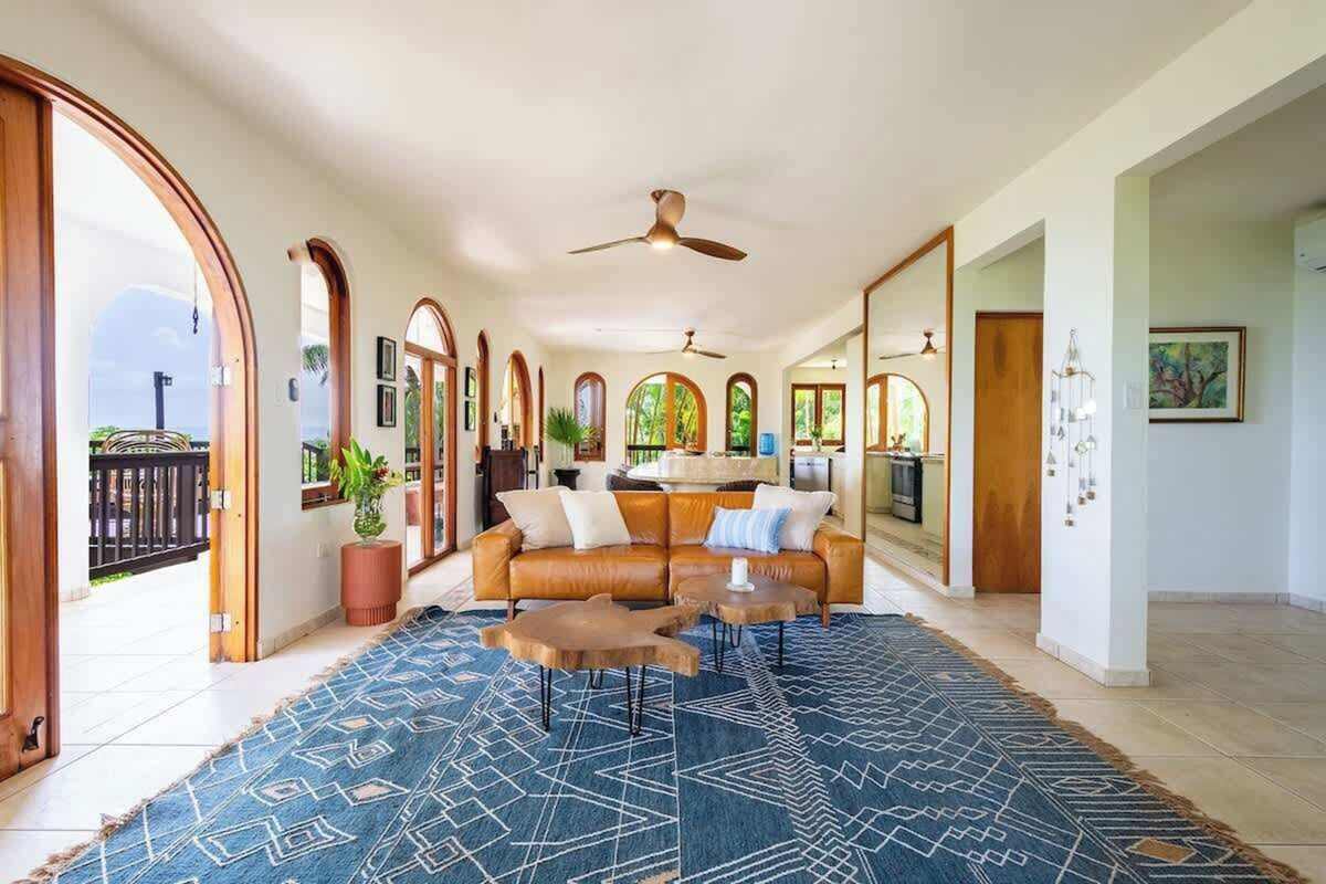 Open-air great room with arched doorways and rattan seating